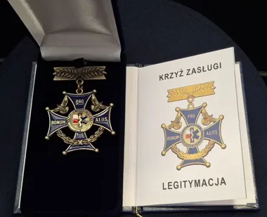 Otwarte etui z Krzyżem Zasługi Polskiego Towarzystwa Ratowniczego oraz legitymacją odznaczenia.