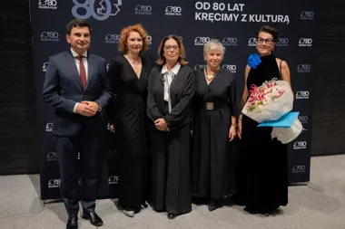 Pięć osób pozuje do zdjęcia podczas uroczystości 80-lecia Silesia Film na tle ścianki z logotypem jubileuszu.